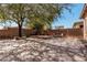 Spacious backyard featuring a large tree, custom patio and seating area, perfect for outdoor entertaining at 19405 W Oregon Ave, Litchfield Park, AZ 85340