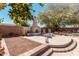 Outdoor fireplace with a shade tree and desert landscaping in a private backyard at 19405 W Oregon Ave, Litchfield Park, AZ 85340