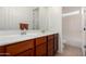 Bathroom features double sinks with wood cabinetry, a large mirror, and a shower with glass doors at 19405 W Oregon Ave, Litchfield Park, AZ 85340