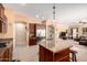 Open kitchen with stainless appliances, a central island with a sink, and a view into the living area at 19405 W Oregon Ave, Litchfield Park, AZ 85340