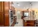 Well-equipped kitchen features stainless steel appliances, wood cabinets, granite counters, and a tiled floor at 19405 W Oregon Ave, Litchfield Park, AZ 85340