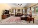 Spacious living room with a large leather sectional sofa, ceiling fan, and an eye-catching oriental rug at 19405 W Oregon Ave, Litchfield Park, AZ 85340