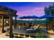 Beautiful backyard with pergola, lounge seating, dining table and chairs, and landscaped garden at sunset at 2034 N Dome Rock --, Mesa, AZ 85207
