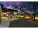 Inviting backyard with a covered patio, lounge chairs, and landscaped yard with decorative lighting at twilight at 2034 N Dome Rock --, Mesa, AZ 85207