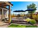 Outdoor patio featuring a pergola, seating, and blue umbrellas in a well-maintained backyard at 2034 N Dome Rock --, Mesa, AZ 85207