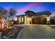 Beautiful home exterior features a paver driveway, stone accents, tile roof, and professional landscaping at dusk at 2034 N Dome Rock --, Mesa, AZ 85207