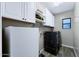 Well-equipped laundry room with white cabinets, a dark washer/dryer set, and a window at 2034 N Dome Rock --, Mesa, AZ 85207