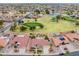 Wide aerial view showcasing a golf course community featuring lush greens, a lake, and well-manicured landscaping at 20827 N Stonegate Dr, Sun City West, AZ 85375