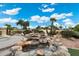 Beautiful backyard featuring a decorative rock waterfall, palm trees and an artificial turf area at 20827 N Stonegate Dr, Sun City West, AZ 85375