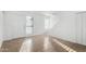 Bright living room with neutral tile flooring, white front door, large windows, and staircase in background at 2842 E Beck Ln # 2, Phoenix, AZ 85032