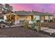 A cozy single-story home featuring desert landscaping and a quaint covered porch under a picturesque twilight sky at 2902 E Avalon Dr, Phoenix, AZ 85016