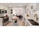 Open concept kitchen with modern stainless steel appliances, island, and dining area access at 2902 E Avalon Dr, Phoenix, AZ 85016