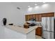 Bright kitchen featuring wood cabinets, stainless steel appliances, and a breakfast bar at 2989 N 44Th St # 3016, Phoenix, AZ 85018