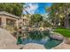 Scenic pond with rock features, lush landscaping, and nearby apartment buildings at 2989 N 44Th St # 3016, Phoenix, AZ 85018