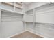 Walk-in closet with carpet flooring, white shelving and hanging rods offering lots of storage at 35207 N Agua Caliente Rd, San Tan Valley, AZ 85144