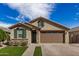 Well-maintained home featuring a two-car garage, manicured lawn, and stone detailing at 35207 N Agua Caliente Rd, San Tan Valley, AZ 85144