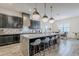Modern kitchen with a granite island, pendant lights, black cabinetry, and seating, perfect for casual dining at 3563 E Austin Dr, Gilbert, AZ 85296