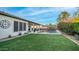 Lush backyard with a sparkling pool, covered patio, and manicured lawn provides a private oasis for relaxation and recreation at 40195 N Hailey Ln, Queen Creek, AZ 85140