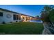 Beautiful backyard with artificial turf, swimming pool, and outdoor living space at dusk at 40195 N Hailey Ln, Queen Creek, AZ 85140