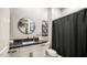 Stylish bathroom with a granite vanity, a round mirror, and a contrasting shower curtain at 40195 N Hailey Ln, Queen Creek, AZ 85140