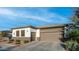 Attractive one-story home with a well-manicured front yard, attached two-car garage, and modern architectural details at 40195 N Hailey Ln, Queen Creek, AZ 85140