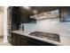 The kitchen features sleek black cabinets, quartz countertops, and stainless steel appliances including a gas range at 40195 N Hailey Ln, Queen Creek, AZ 85140
