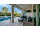 Inviting patio with comfortable seating and an outdoor fireplace, offering a serene view of the pristine swimming pool and backyard at 40195 N Hailey Ln, Queen Creek, AZ 85140