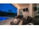 Cozy outdoor patio with a fire pit, comfortable seating, and a view of the lush backyard and pool area at 40195 N Hailey Ln, Queen Creek, AZ 85140