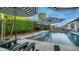 Luxurious swimming pool with umbrellas and lounge chairs, set amidst lush landscaping creating a private and serene retreat at 40195 N Hailey Ln, Queen Creek, AZ 85140
