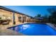 Inviting backyard pool area featuring stylish patio furniture, shade umbrellas, and a serene ambiance at dusk at 40195 N Hailey Ln, Queen Creek, AZ 85140
