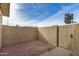Private backyard with a textured stucco wall, gated access, and gravel ground cover for low maintenance at 4436 E Pueblo E Ave, Phoenix, AZ 85040