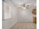 Bright dining room featuring tile flooring, a ceiling fan, a window with blinds, and a partial view of the kitchen at 4436 E Pueblo E Ave, Phoenix, AZ 85040