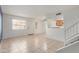 Bright open-concept living area with tile flooring, staircase, and seamless flow to dining and kitchen at 4436 E Pueblo E Ave, Phoenix, AZ 85040