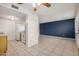 Open-concept kitchen and living area with tile flooring, stainless steel refrigerator, and blue accent wall at 4436 E Pueblo E Ave, Phoenix, AZ 85040