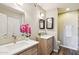 Bathroom featuring double sinks, two mirrors and wood cabinets at 4530 W Continental Dr, Glendale, AZ 85308