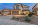 Two-story home featuring a tidy desert rock garden, a two-car garage, and well-kept landscaping at 4535 W Cottontail Rd, Phoenix, AZ 85086