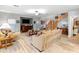 Spacious living room with plank floors, a ceiling fan, tan couches, and stairs to the second floor at 4535 W Cottontail Rd, Phoenix, AZ 85086