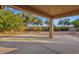 Large, covered back patio with decorative column overlooking a landscaped backyard at 4937 S Peach Willow Ln, Gilbert, AZ 85298