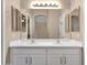 Bathroom featuring a double vanity with framed mirror and a view to the Primary bedroom at 4937 S Peach Willow Ln, Gilbert, AZ 85298