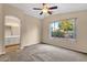 Comfortable bedroom with carpet, ceiling fan and a view of the backyard at 4937 S Peach Willow Ln, Gilbert, AZ 85298