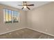 Well-lit bedroom with a ceiling fan and a large window at 4937 S Peach Willow Ln, Gilbert, AZ 85298