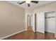 Bright bedroom featuring a ceiling fan, closet, and wood flooring at 4937 S Peach Willow Ln, Gilbert, AZ 85298