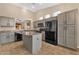 Spacious kitchen features gray cabinets, granite countertops, black appliances and a center island at 4937 S Peach Willow Ln, Gilbert, AZ 85298