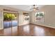 Bright living room with hardwood floors, a ceiling fan, and sliding doors to the backyard at 4937 S Peach Willow Ln, Gilbert, AZ 85298