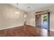 Open-concept living space featuring hardwood floors, a modern light fixture, and sliding glass doors to backyard at 4937 S Peach Willow Ln, Gilbert, AZ 85298