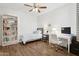 Well-lit bedroom featuring wood floors, a ceiling fan, and a dedicated workspace at 5303 N 7Th St # 215, Phoenix, AZ 85014