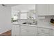 Contemporary kitchen with white cabinets, stainless steel sink, and view of the living area at 5303 N 7Th St # 215, Phoenix, AZ 85014