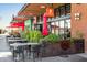 Elly's Brunch & Cafe exterior featuring outdoor seating area with red umbrellas and greenery at 5303 N 7Th St # 215, Phoenix, AZ 85014