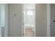 Hallway view of a bright, white bathroom with a bathtub and shower combination at 57856 W Fulcar Rd, Maricopa, AZ 85139