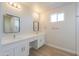 Well-lit bathroom featuring double sinks, vanity area, modern mirrors, and wood look flooring at 57856 W Fulcar Rd, Maricopa, AZ 85139